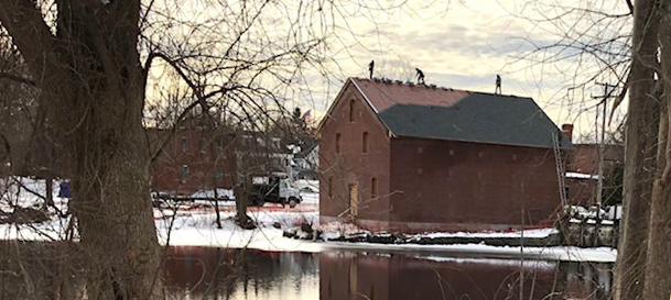 Roofers completing the fi nal courses of shingles on December 23, 2020