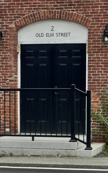 The entrance facing Old Elm Street with new metal signage above the door.